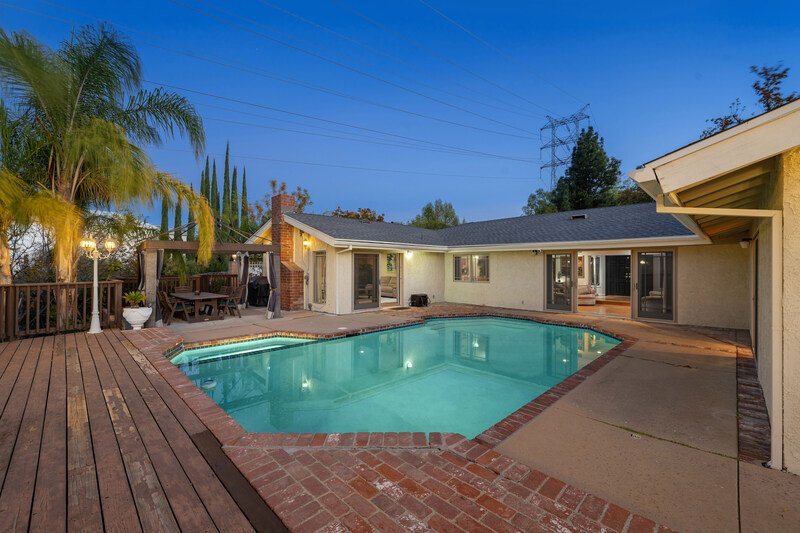 casa con alberca en un atardecer casi noche casa amplia de un pico colores neutros